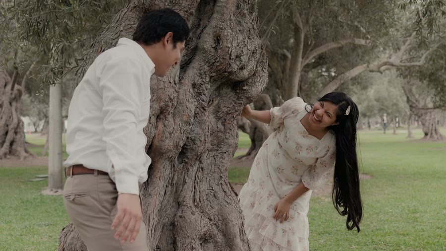Yenifer jugando detrás del árbol